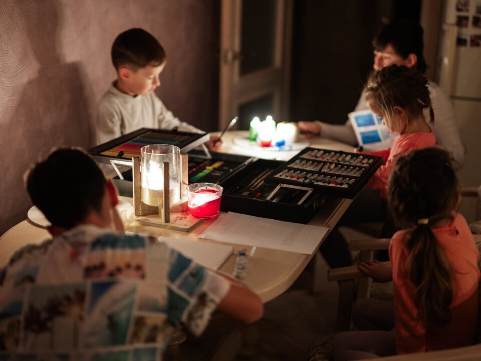 Niños estudiando a la luz de las velas
